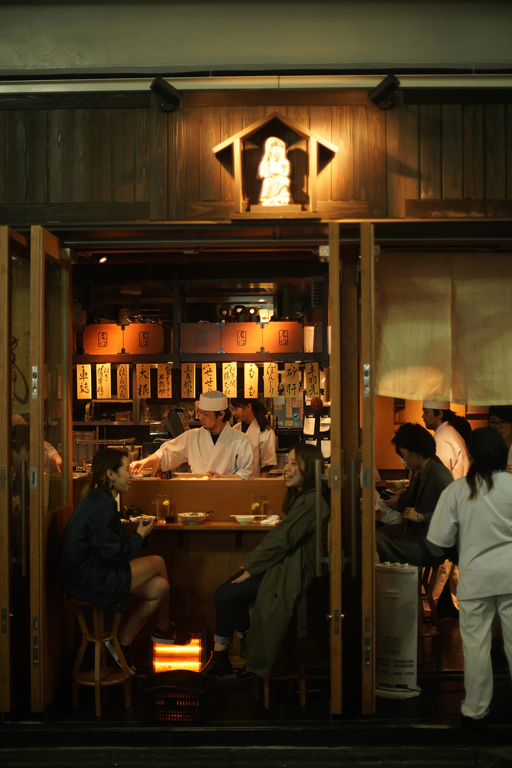 Traditional Japanese izakaya storefront with warm lantern glow