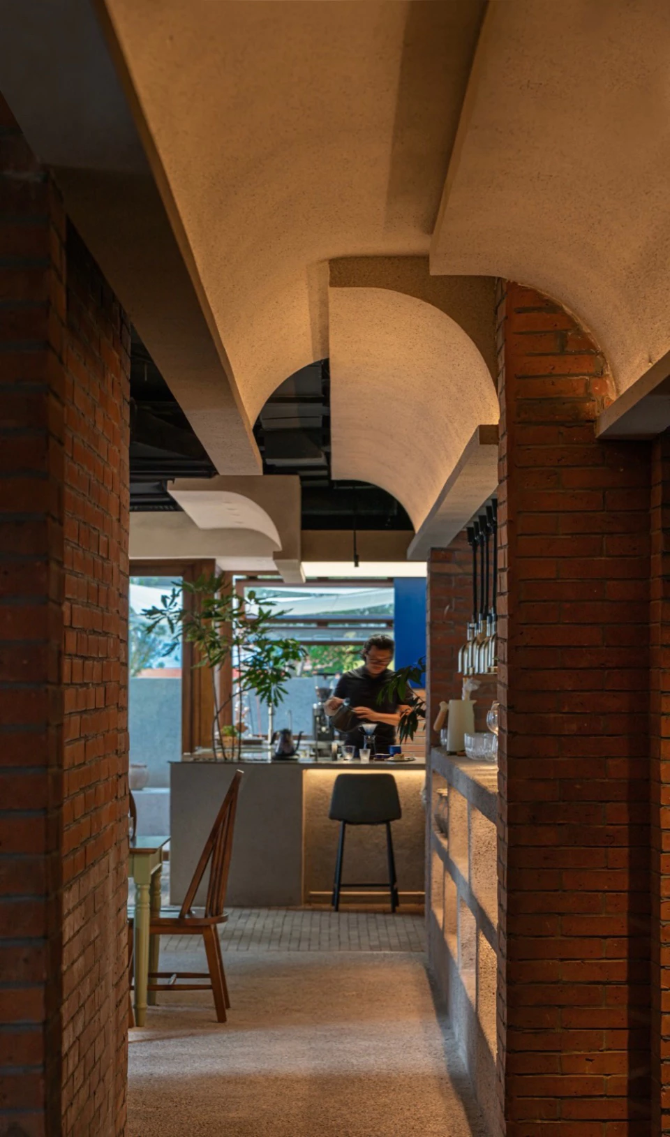 Cafe interior with brick arches and vaulted concrete ceiling
