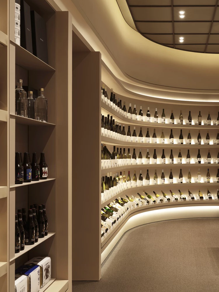 Curved wine cellar with backlit shelving displaying bottles