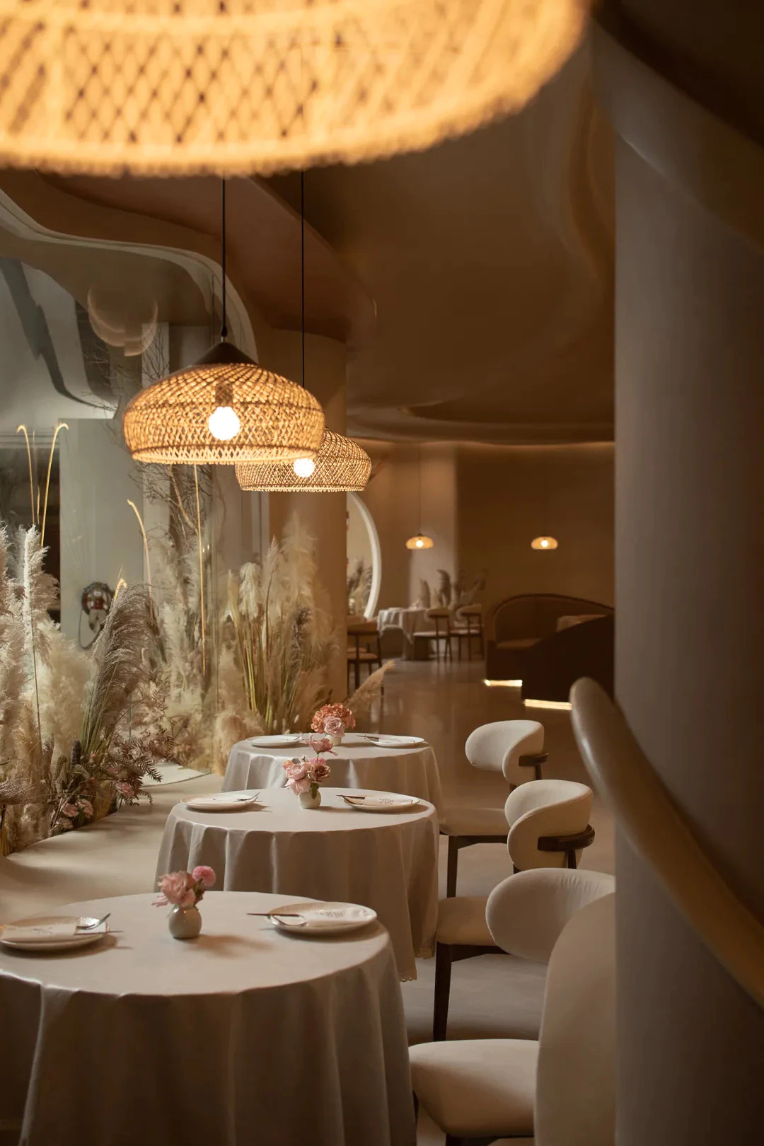 Elegant restaurant with rattan pendant lamps and pampas grass decor